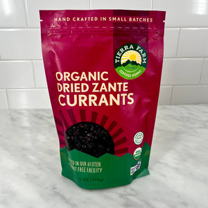 Packaging of organic dried Zante currants on a kitchen counter.
