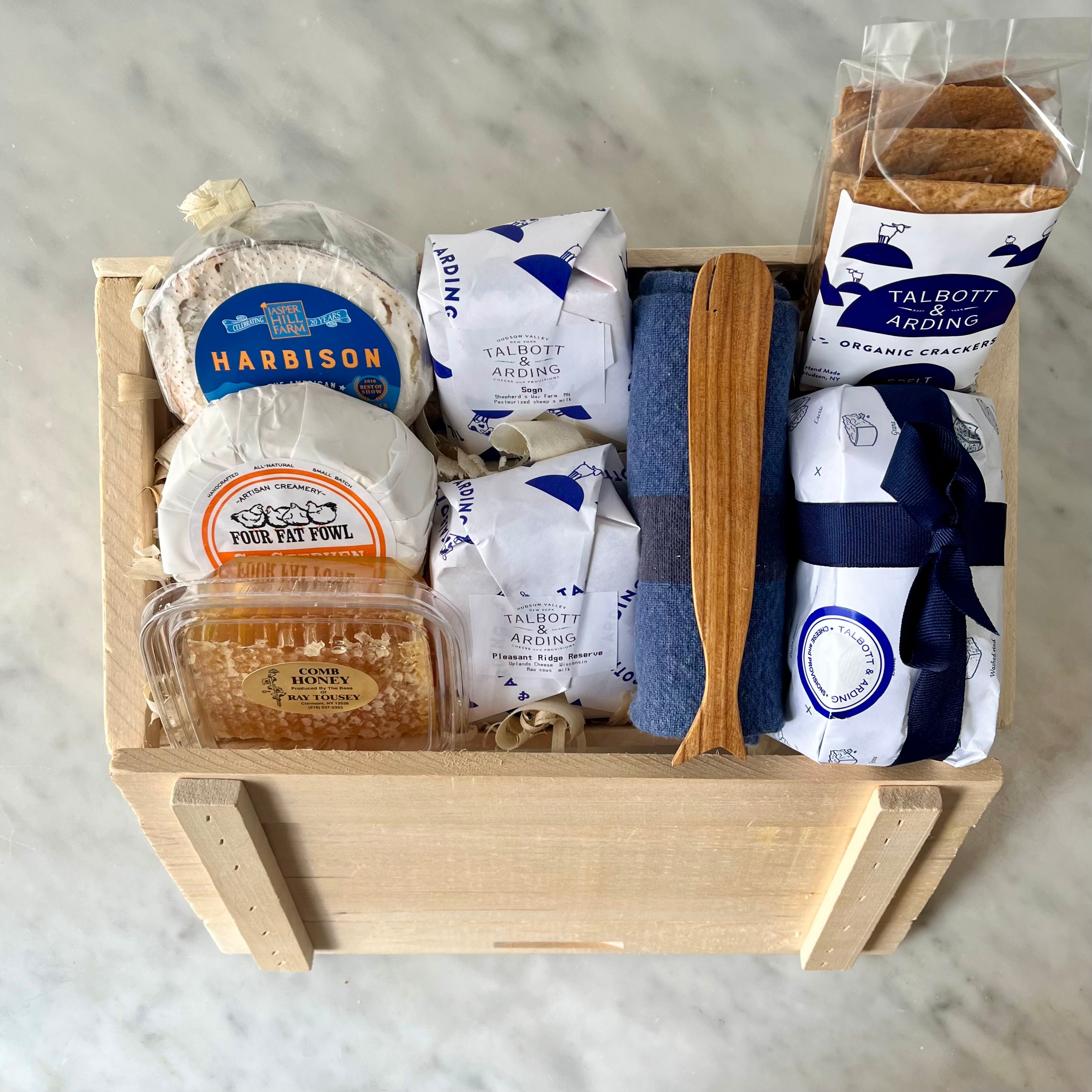 Gourmet food items in a wooden gift box.