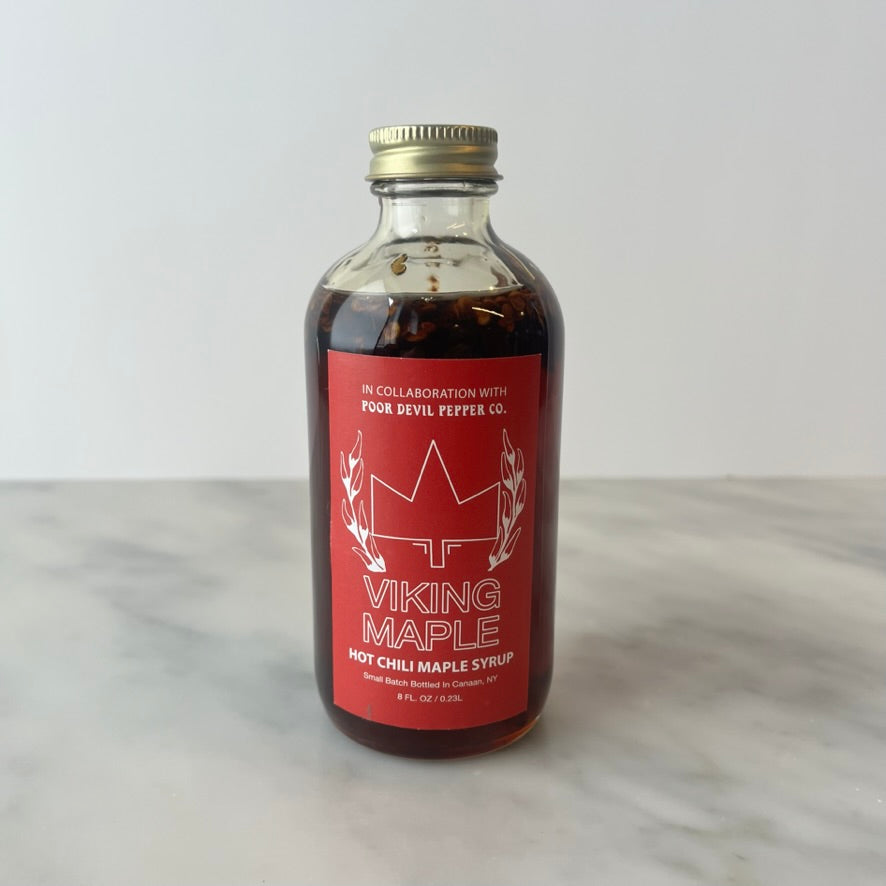 A bottle of Viking Maple hot chili maple syrup on a counter.