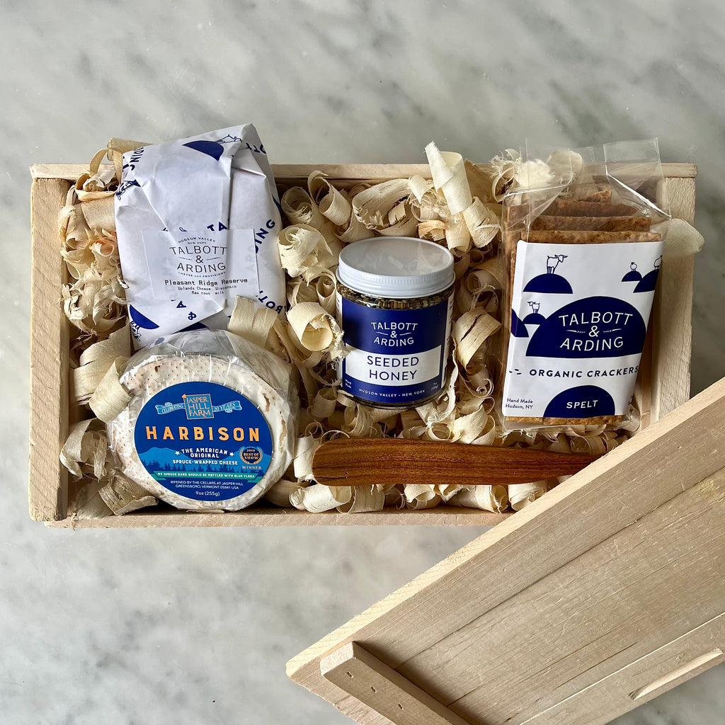 Gourmet cheese, honey, and crackers in a wooden gift box.