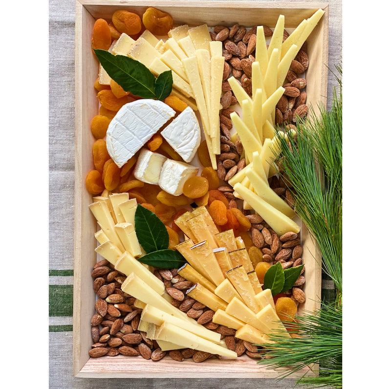 A cheese and nut platter with dried apricots.