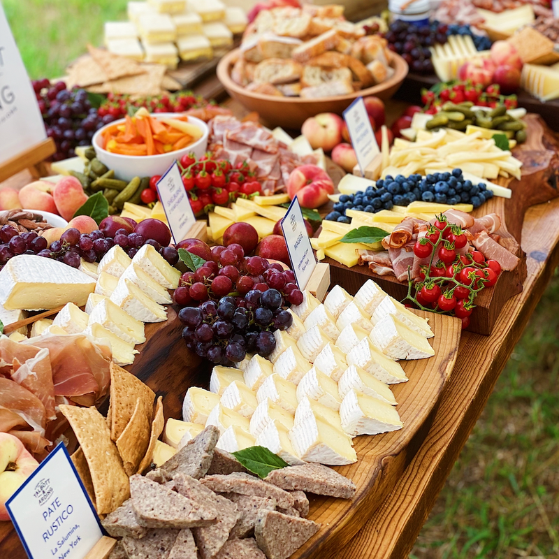 Assorted cheese and charcuterie spread on a wooden table.