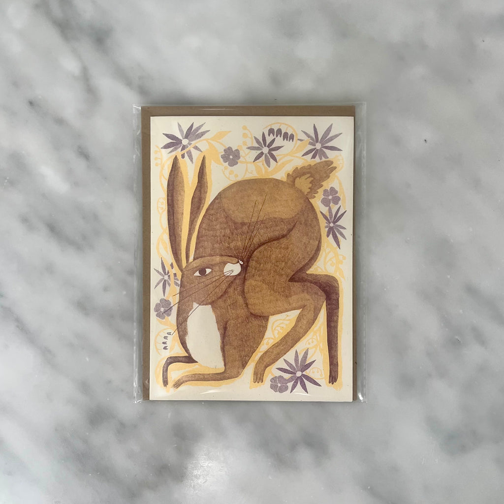Illustration of a brown rabbit with floral background on a card.