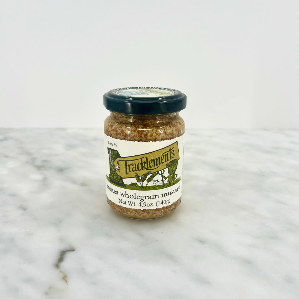 Jar of wholegrain mustard on a marble surface.