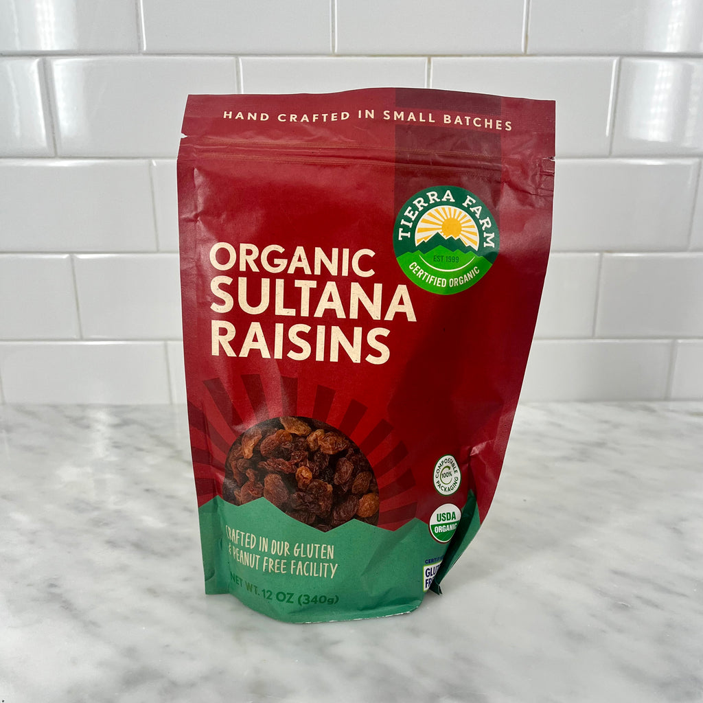 Package of organic sultana raisins on a kitchen counter.