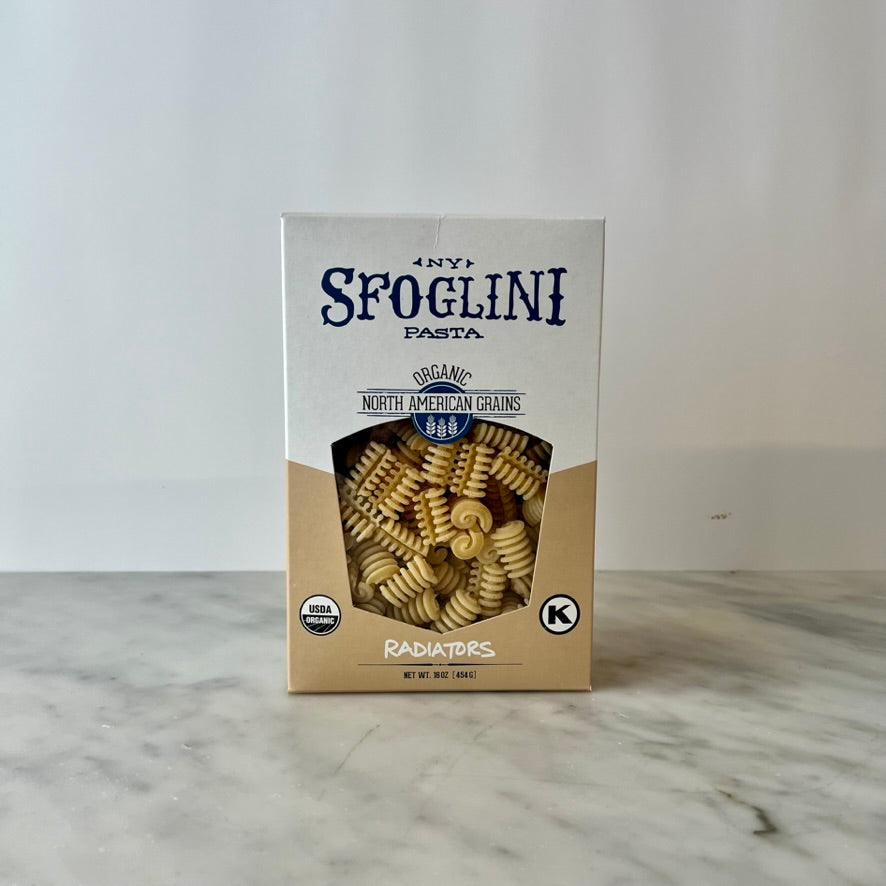 Box of Sfoglini pasta on a marble surface.