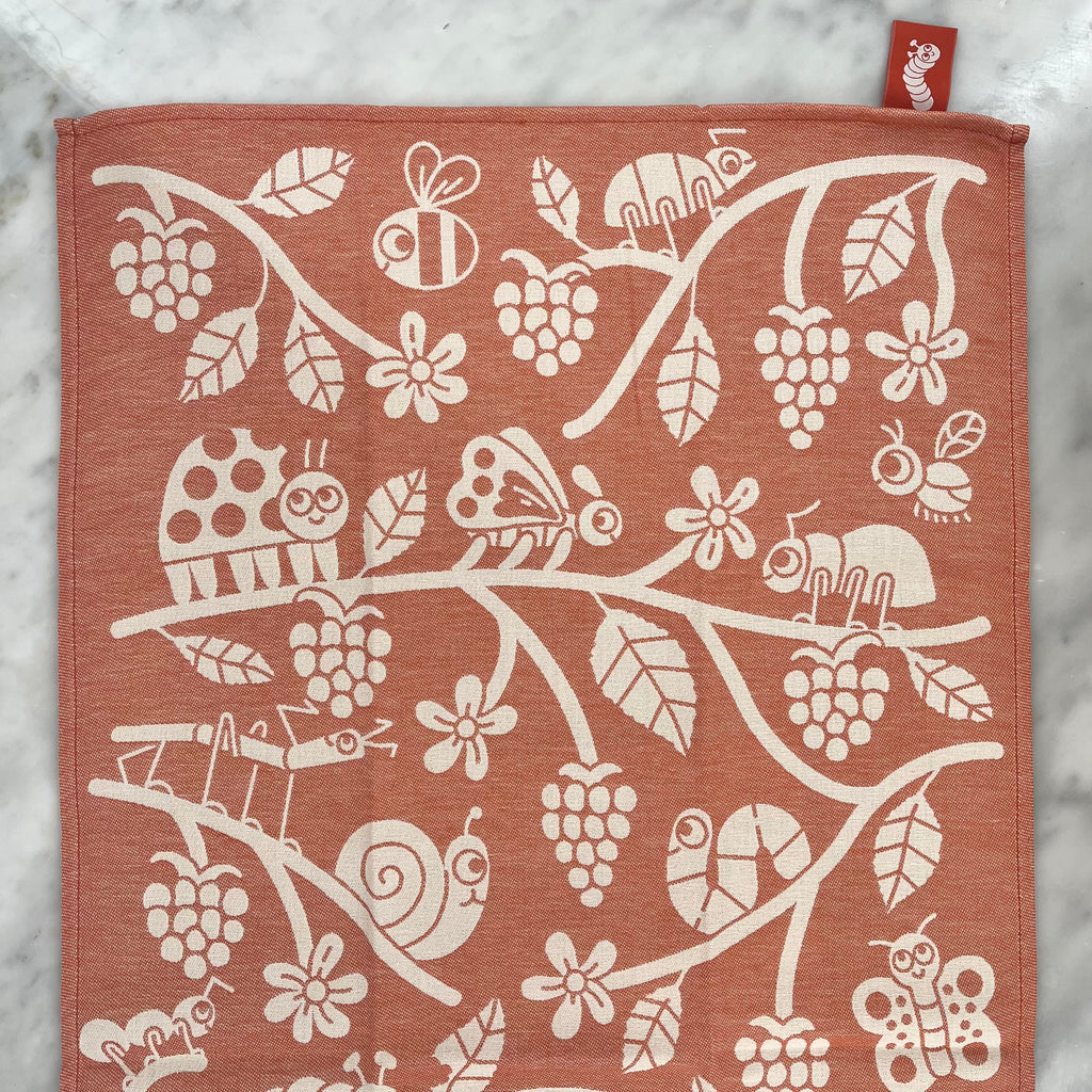 Patterned fabric with insects and plants.