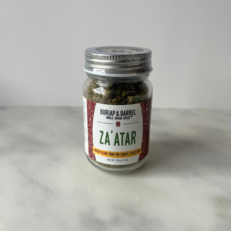 Jar of za'atar spice on a countertop.