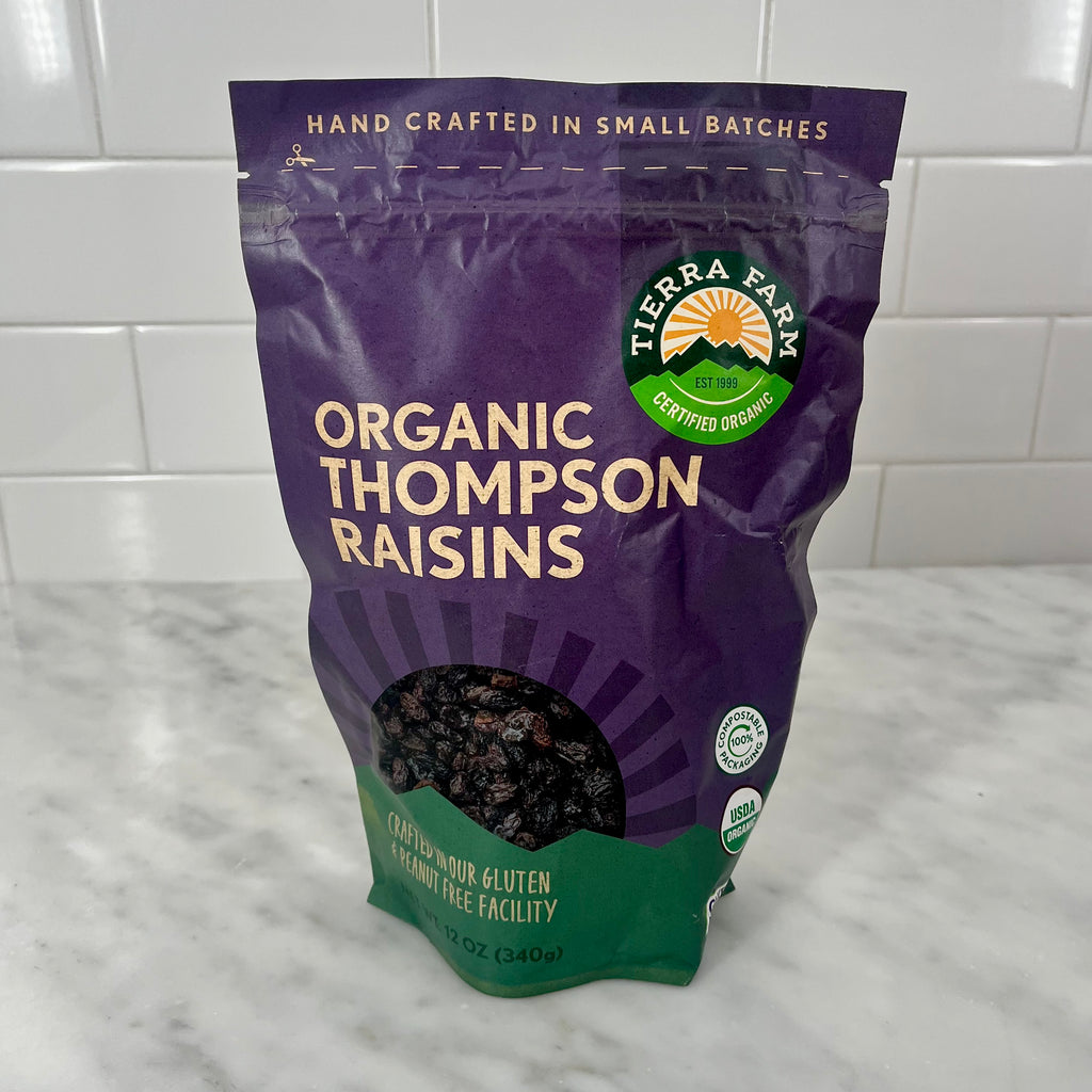A bag of organic Thompson raisins on a kitchen counter.