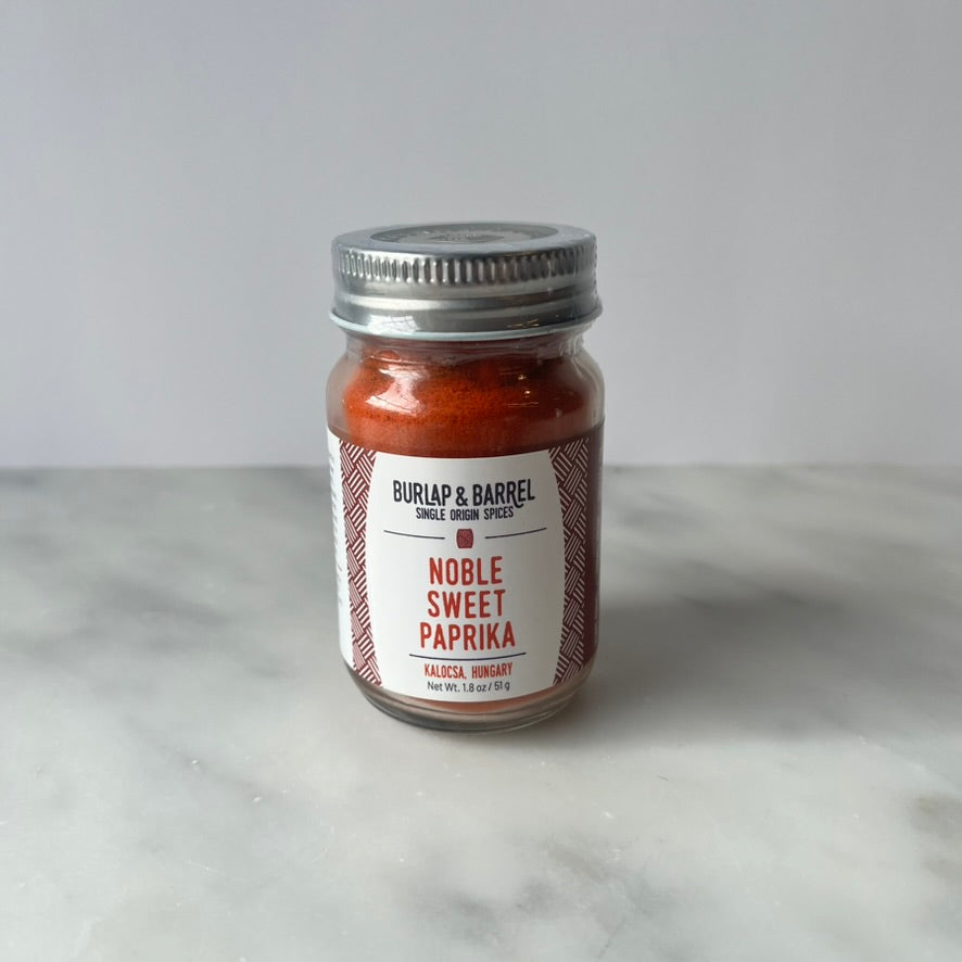 Jar of Noble Sweet Paprika on a marble surface.
