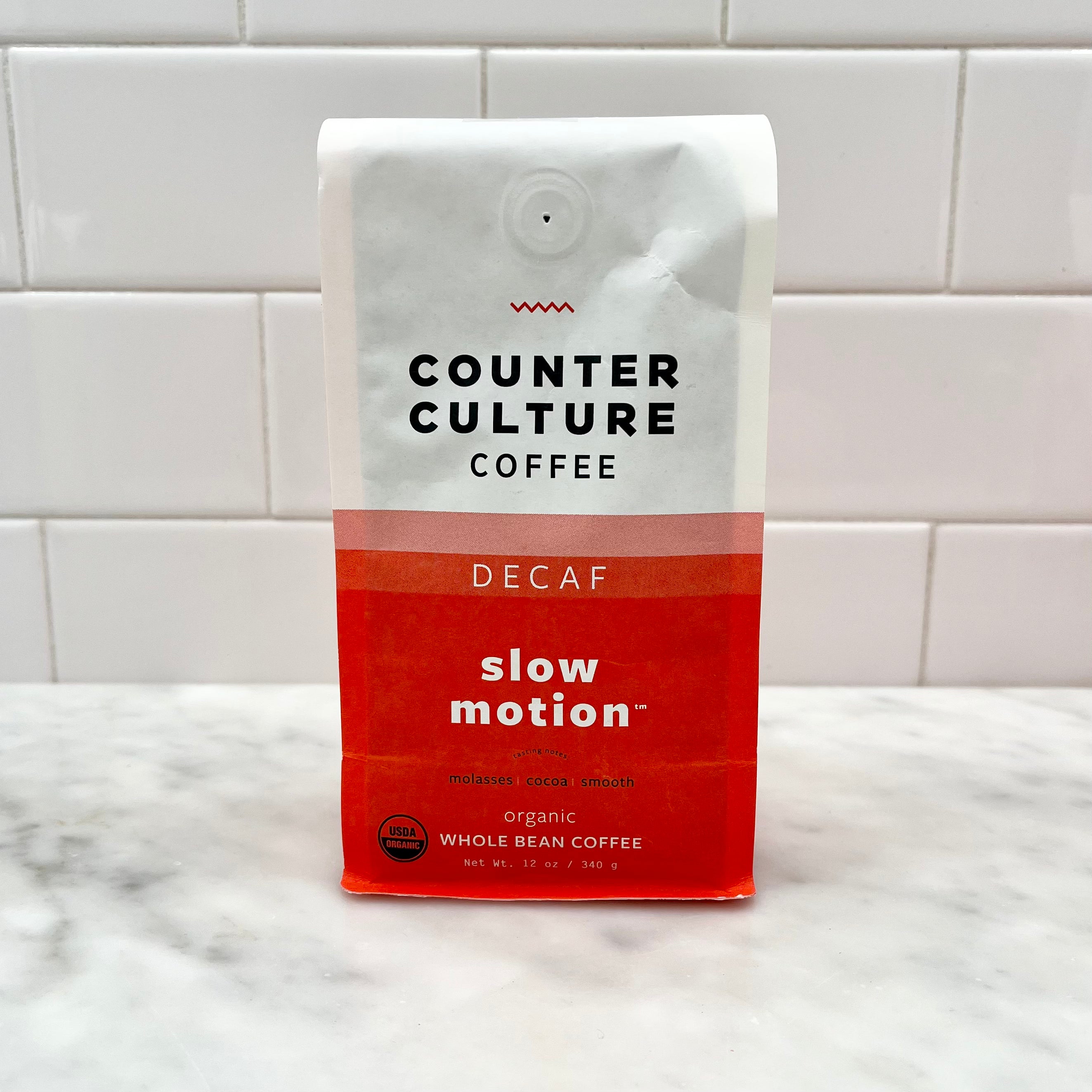 A bag of Counter Culture Decaf Slow Motion Whole Bean Coffee on a counter.