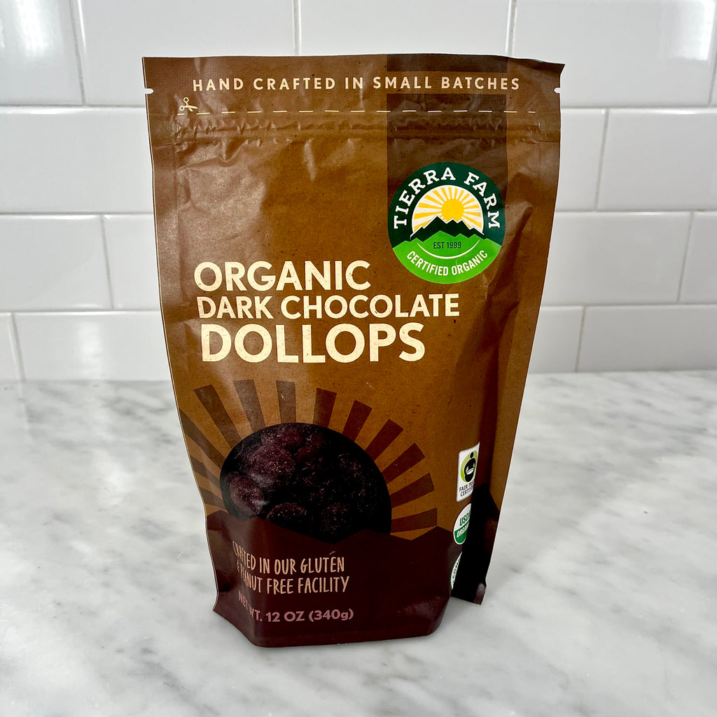 Bag of organic dark chocolate dollops on a kitchen counter.