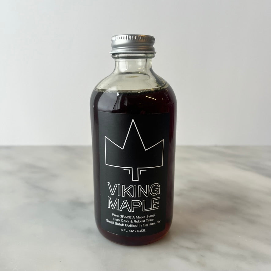 A bottle of maple syrup on a table.