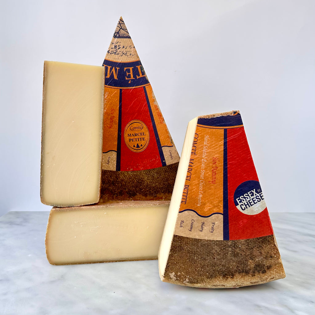 Two wedges of Comté cheese with labels.