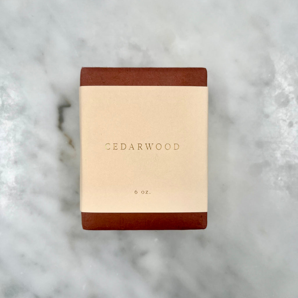 Cedarwood soap bar on marble surface.