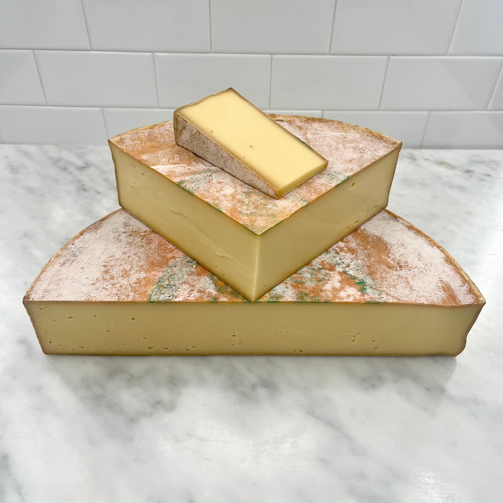 A stack of cheese wedges on a marble surface.