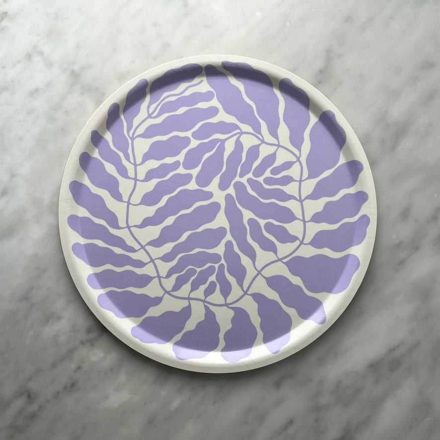 Round plate with a lilac leaf pattern on a marble background.