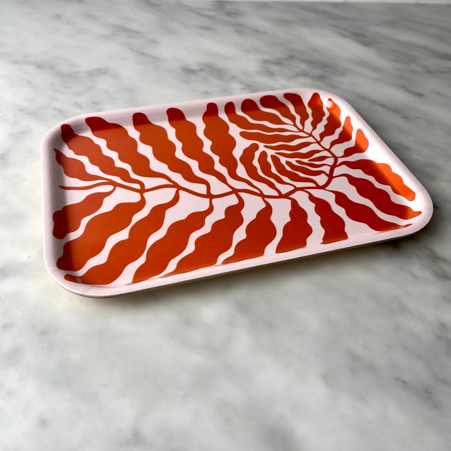 Decorative tray with leaf pattern on marble surface.