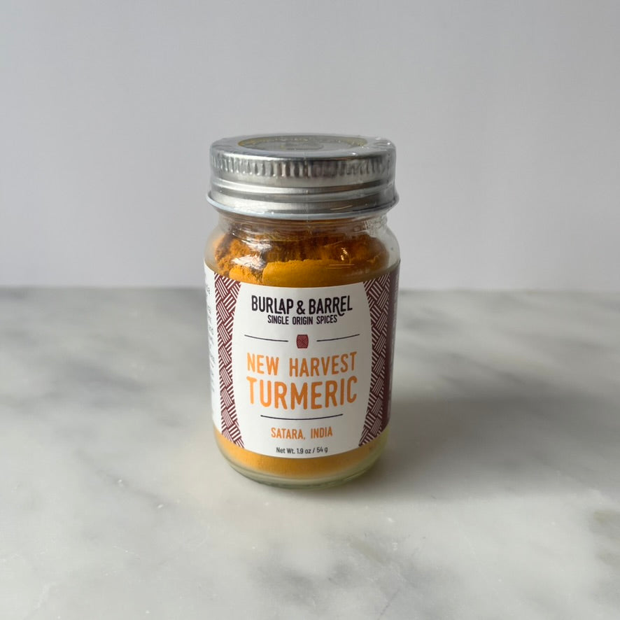 Jar of turmeric on a table.