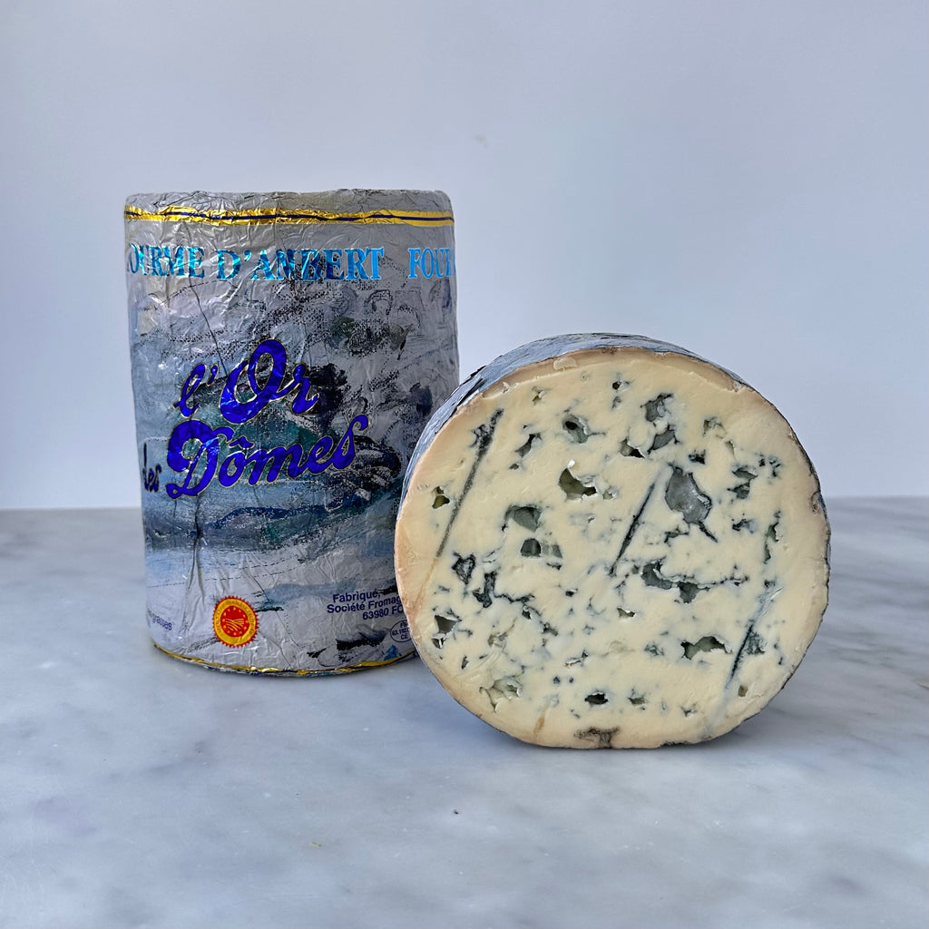 A wheel of blue cheese with its packaging.