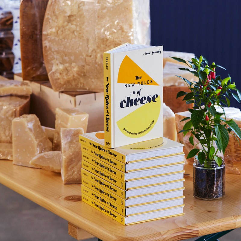 A table displaying Parmigiano Reggiano and cheese books.
